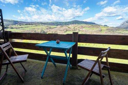 a blue table and two chairs on a porch with a view at Hotel Alma de Romero in Carranza