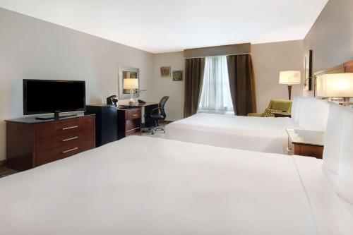 a hotel room with two beds and a flat screen tv at Cypress Bend Resort, a Wyndham Hotel in Many
