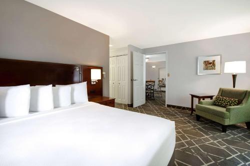 a hotel room with a large bed and a chair at Cypress Bend Resort, a Wyndham Hotel in Many