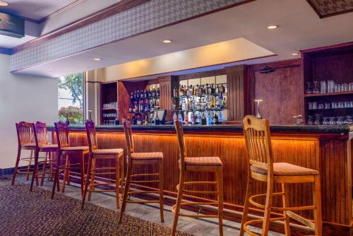 a bar with wooden stools in a restaurant at Cypress Bend Resort, a Wyndham Hotel in Many
