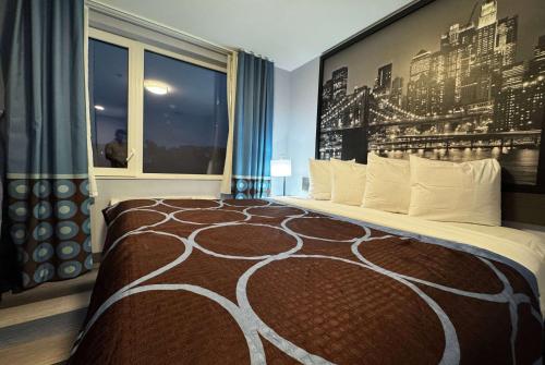 a bedroom with a large bed with a large wall at Super 8 by Wyndham Brooklyn Fulton Street Broadway Junction in Brooklyn