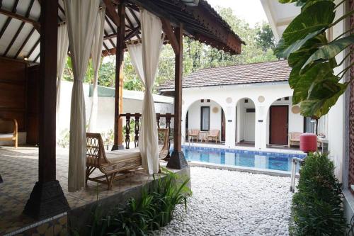 a pavilion with a chair and a swimming pool at Villa de Tristan Yogyakarta in Mutihan