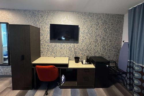 an office with a desk with a monitor on a wall at Super 8 by Wyndham Brooklyn Fulton Street Broadway Junction in Brooklyn