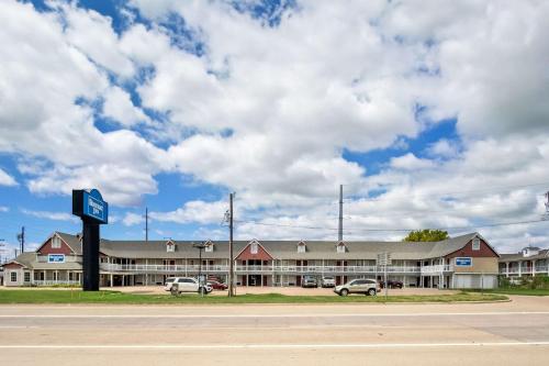 a large building with cars parked in front of it at Rodeway Inn in Waco