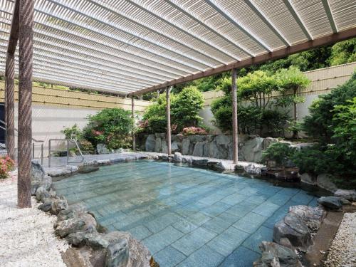 a large swimming pool with a pergola at Grand Mercure Minamiboso Resort & Spa in Minamiboso