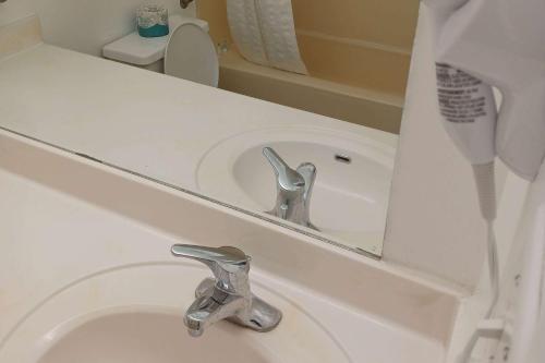 a bathroom sink with a mirror and a faucet at Howard Johnson by Wyndham Springerville in Springerville