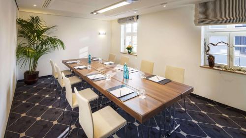 a conference room with a long wooden table and chairs at Hilton Frankfurt Gravenbruch in Gravenbruch