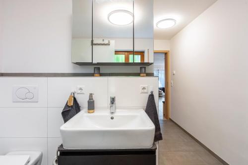 a white sink in a bathroom with white walls at Ferienwohnung Sonnenberg in Degerfelden
