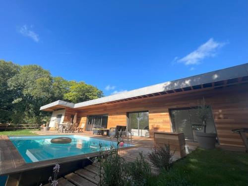 une maison avec une piscine devant dans l'établissement Un havre de paix au pied du Golf, à Saint-Martin-du-Vieux-Bellême