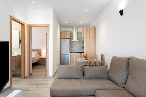 a living room with a couch and a kitchen at Viviendas Turísticas El Moral in Vejer de la Frontera