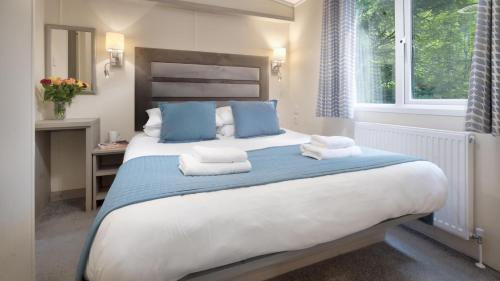 a bedroom with a large bed with towels on it at Newby Bridge Country Caravan Park in Newby Bridge