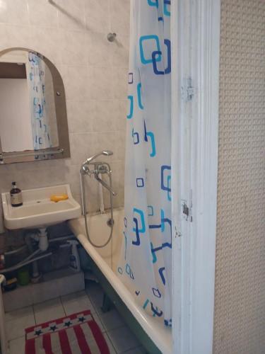 a bathroom with a shower curtain and a sink at Чорних Запорожців 17, інститут серця in Kyiv