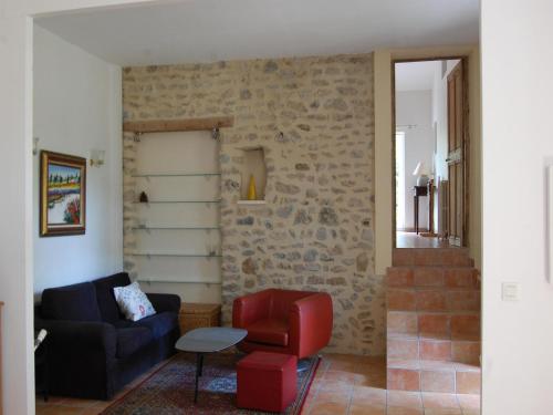 un salon avec un canapé et une chaise dans l'établissement Villa in Valréas with Pool and Garden Views, à Valréas