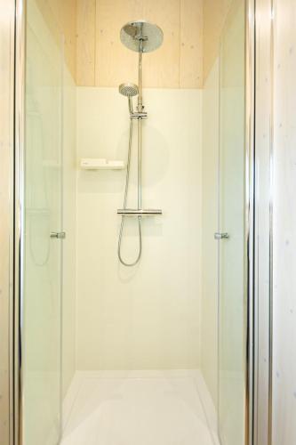 a bathroom with a shower with a glass door at Vrijbuiter - Ecohuisjes Terschelling in Midsland