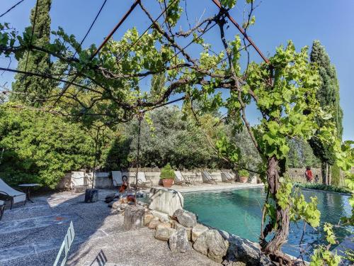 MaubecにあるCottage in Oppède with Pool and Gardenの木とブランコのあるスイミングプール