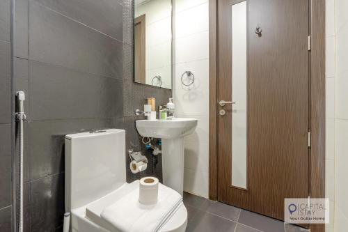 a bathroom with a toilet and a sink at Capital Stay - Cozy Studio in Liwan Dubai in Dubai