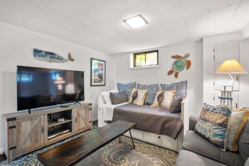 a living room with a flat screen tv and a couch at Game Room Walk to Nantucket Sound in Chatham