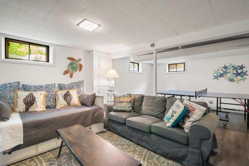 a living room with a couch and a table at Game Room Walk to Nantucket Sound in Chatham