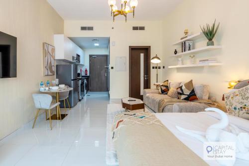 a living room with a couch and a table at Capital Stay - Cozy Studio in Liwan Dubai in Dubai