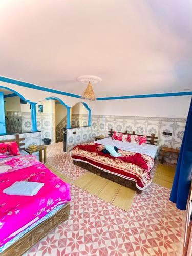 a bedroom with two beds in a room with blue walls at Binic guest house in Taghazout