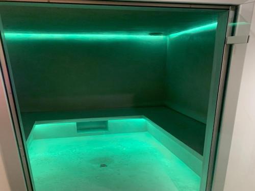 - une douche en verre avec des lumières bleues dans la chambre dans l'établissement Château in Normandy near D-Day Beaches, à Lantheuil