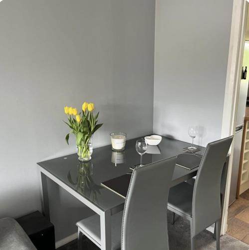 a dining room table with a vase of flowers on it at Townhead Road in Inverurie
