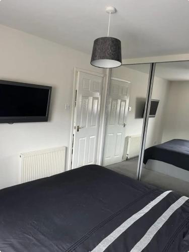 a bedroom with a bed and a flat screen tv at Townhead Road in Inverurie