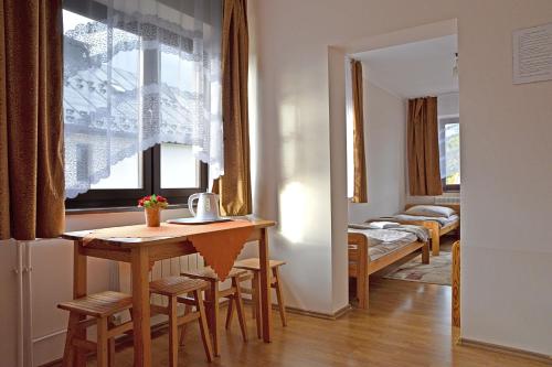 a room with a table and a window and a bedroom at Pokoje Gościnne u Wioli in Jurgów