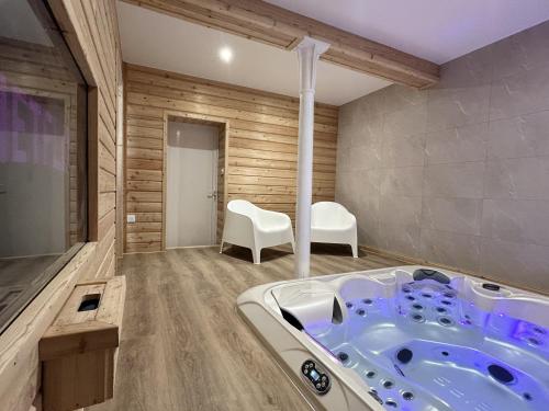 una bañera de hidromasaje en una habitación con paredes de madera en Charmant quadruplex au cœur de la Vallée, en La Broque
