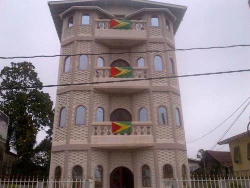 a tall tower with flags in front of it at The Durban Hotel Guyana INC. in Georgetown