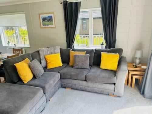 a living room with a gray couch with yellow pillows at Hollicarrs - Newlands in York