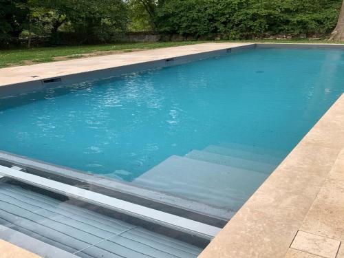 - une piscine d'eau bleue dans l'établissement Manor in Normandy with Spa and Pool, à Lantheuil