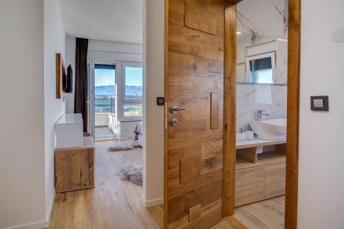 a wooden door in a bathroom with a sink at Villa Dona ZadarVillas in Nin