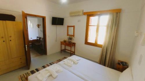 a room with a bed and a mirror and a window at Diamanti Molivos Studios & Apartments in Mithymna