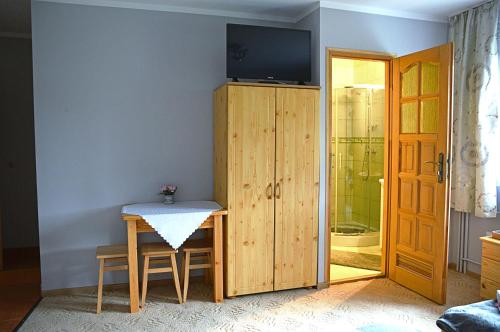 a room with a table and a television on a wall at Pokoje Gościnne u Wioli in Jurgów