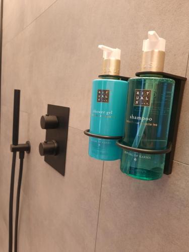 two bottles ofodorizers on a wall in a bathroom at Hotel Hallensis in Halle