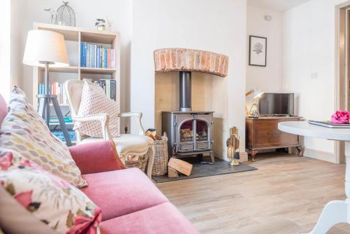 a living room with a fireplace and a pink couch at 4 Northgate, Beccles in Beccles
