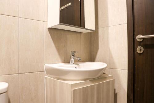 a bathroom with a white sink and a mirror at Best Choice and New 2BR at Citra Living Apartment By Travelio in Jakarta