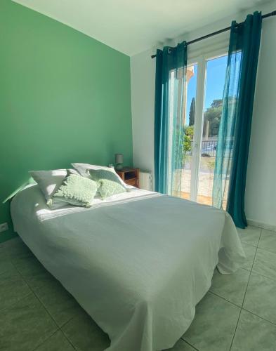 une chambre avec un grand lit blanc et une fenêtre dans l'établissement Maison avec piscine et jardin, à Salses-le-Chateau