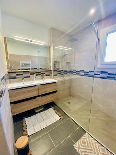 une salle de bain avec une douche en verre et un lavabo dans l'établissement Maison avec piscine et jardin, à Salses-le-Chateau