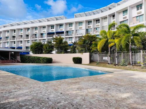 a hotel with a swimming pool in front of a building at Ubicación genial a 3 minutos de combate Beach in El Combate