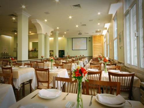 un restaurante con mesas y sillas con flores. en Hotel Regina Rio de Janeiro, en Río de Janeiro