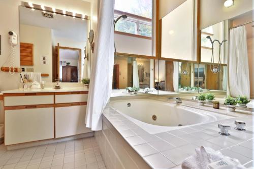 a large bathroom with a tub and a large mirror at Woods Resort and Spa A7 - Cozy 2-Bedroom Condo with Skiing, Tennis, Spa, Hot Tub and Pool Access in Killington