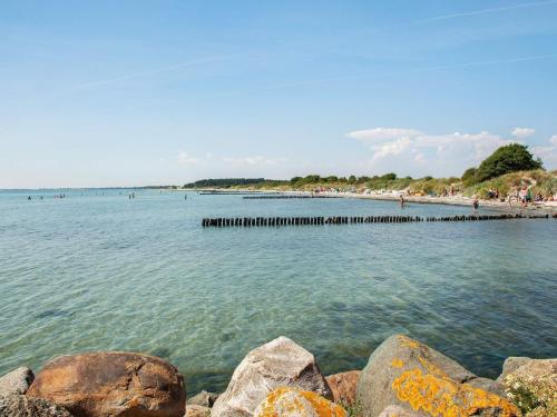 a beach with rocks and people in the water at Apartment Borre XII in Borre