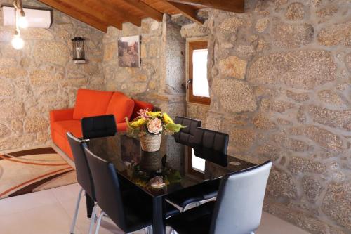 a dining room with a table and an orange couch at Casa do Alto in Oliveira de Frades