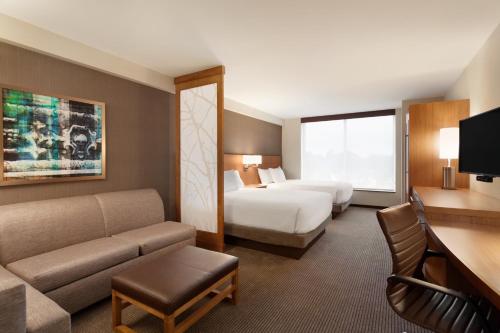 une chambre d'hôtel avec un lit et un canapé dans l'établissement Hyatt Place Buffalo / Amherst, NY, à Amherst