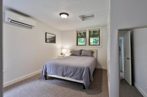 a bedroom with a bed and two windows at The Mendon Cottage - Charming Vermont Home Close to Pico, Ski Rental Deals! in Mendon