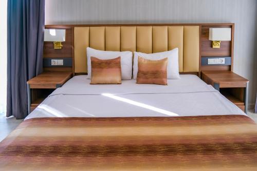 a bedroom with a large white bed with two tables at Days Inn by Wyndham Alanya in Alanya