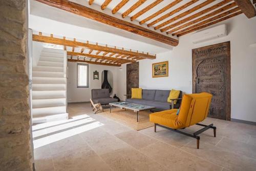 un salon avec une chaise jaune et un canapé dans l'établissement Maison d'exception au cœur de Goult, à Goult
