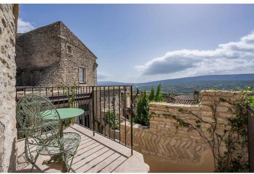 un patio avec une table et des chaises sur un balcon dans l'établissement Maison d'exception au cœur de Goult, à Goult